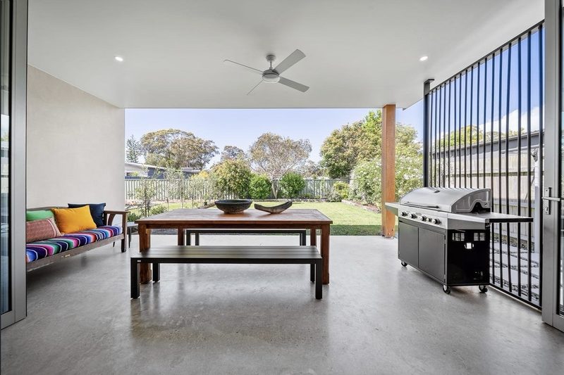 Full sized covered outdoor space with wide steps connecting to the garden