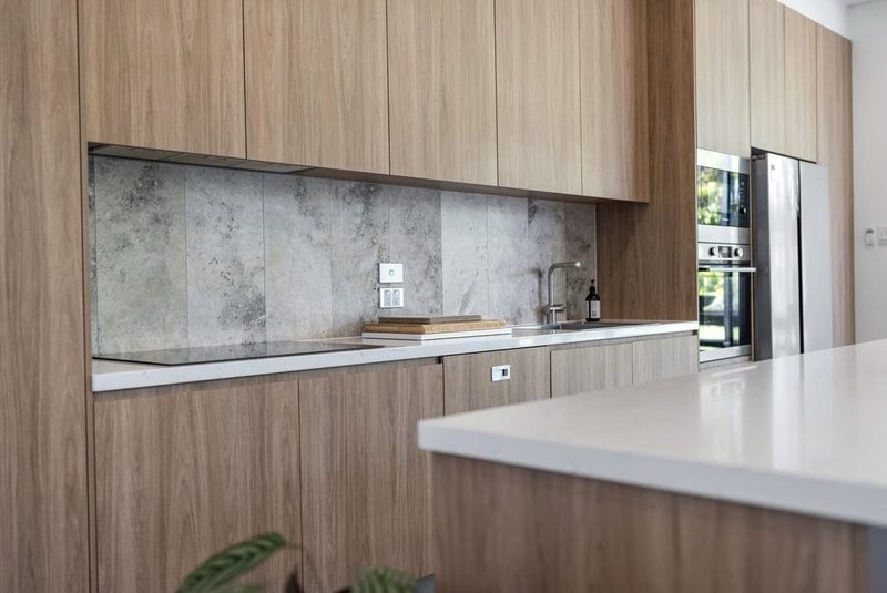 Warm timber finishes matched with cool smoky marble in the kitchen and throughout the homes