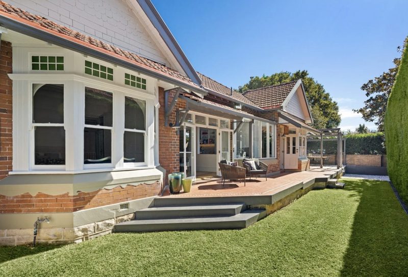 Rear elevation of a heritage brick home with leadlight windows above new landscaping and terracing, Mosman