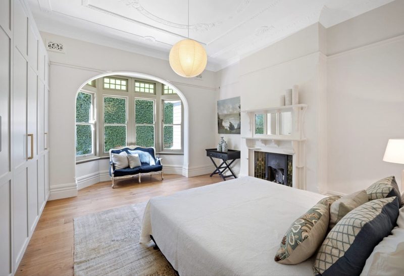 Period bedroom with arched windows and an original fireplace in a Federation home, Mosman
