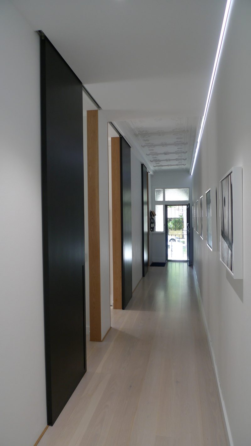 Sliding full height doors with secret overhead tracking — this is a clever way of creating space in a small house