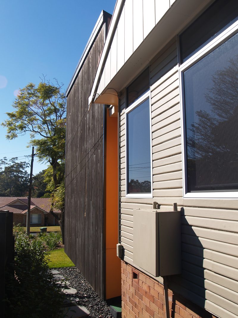 Dark timber cladding of the addition meeting the original weatherboards
