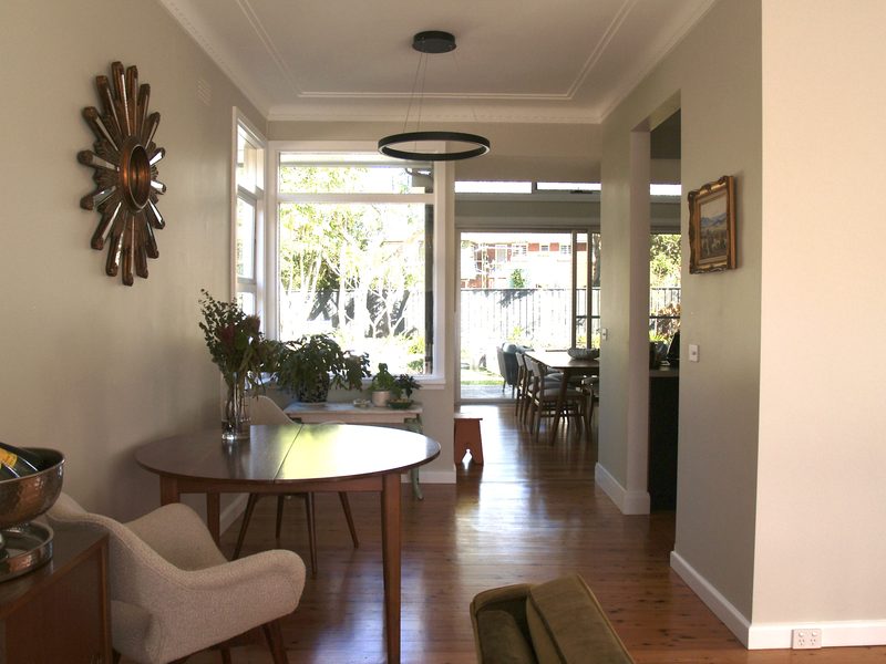 Dining area under a round pendant, looking through the house