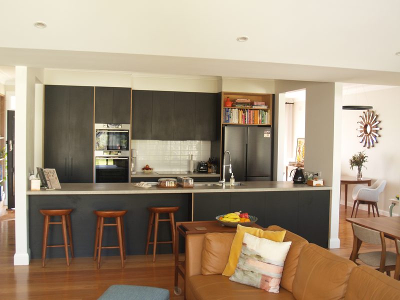 Open kitchen with dark joinery and an island bench